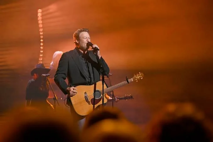 Country singer performing in warm orange stage light